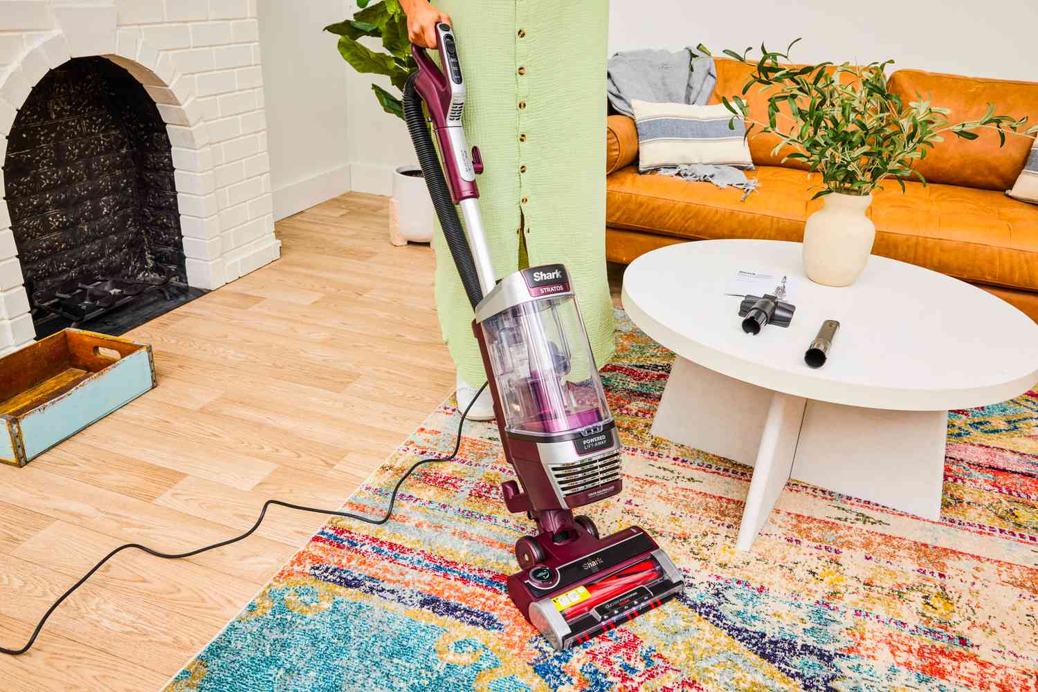 A person uses the Shark Stratos AZ3000 Upright Vacuum with DuoClean PowerFins HairPro on a colorful rug