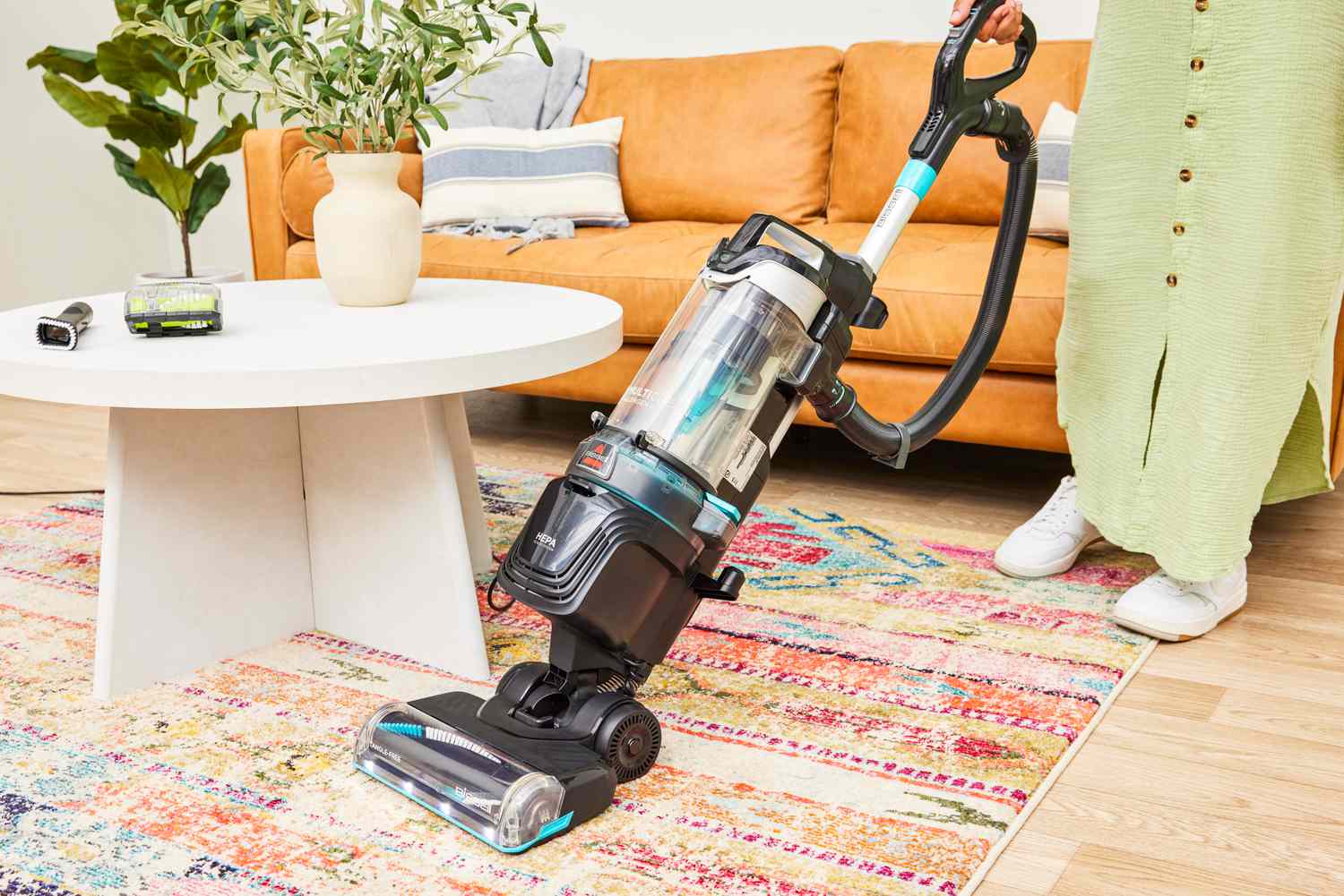 A person uses the Bissell MultiClean Allergen Rewind Pet Vacuum on carpet