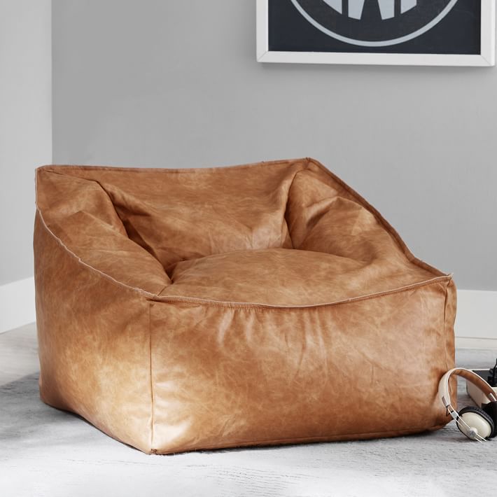 Pottery Barn Teen Vegan Leather Modern Lounger displayed in corner of room with nearby headphones